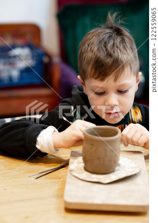 A boy creates a pot and decorating in a pottery workshop 122559065