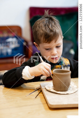 A boy creates a pot and decorating in a pottery workshop 122559066