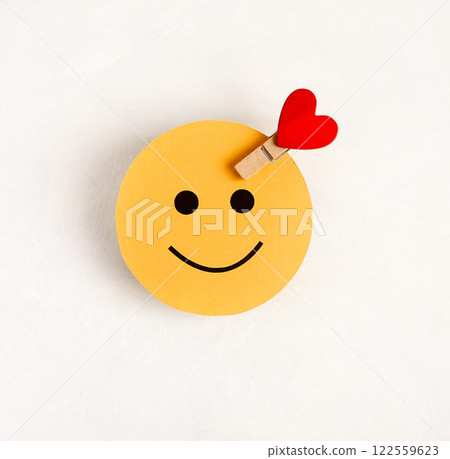 The symbol of a happy person is a round face with a heart on a white background. 122559623