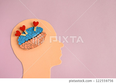 Symbol of a human head and a brain filled with hearts. Concept of a happy or loving person. Mental health and stroke prevention. 122559756