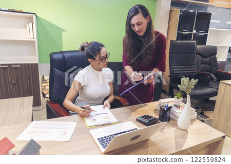Diversity Two Businesswoman working together in office desk. Two cuacasian asian women look at financial report document as partner teamwork. Team leader coworker brainstorming executive entrepreneur 122559824