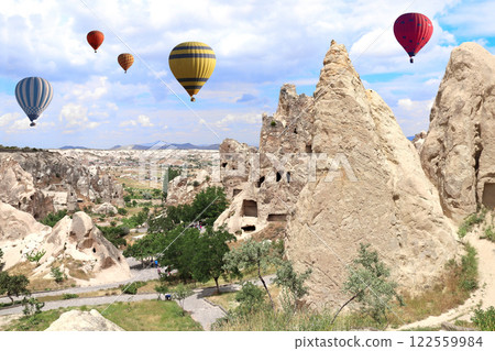 The balloon flight, famous tourist attraction of Cappadocia. Air balloons and Fairy Chimney (multihead stone mushrooms) in Pasabag Valley, Cappadocia, Anatolia, Turkey 122559984