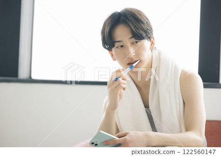 美女圖：一位男士一邊刷牙一邊看智慧型手機 122560147