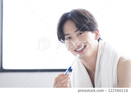 Young man brushing his teeth Young man brushing his teeth 122560218