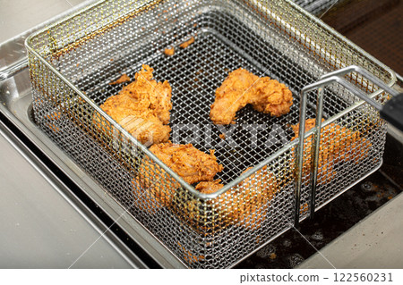 Frying golden chicken wings in deep fryer 122560231