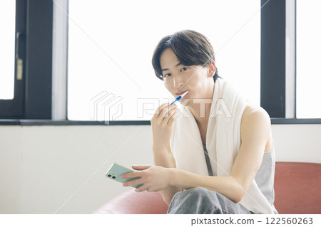 美女圖：一位男士一邊刷牙一邊看智慧型手機 122560263