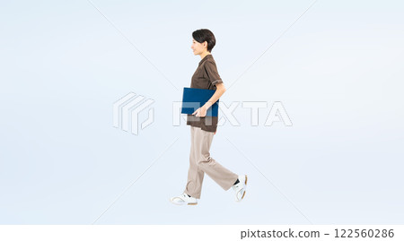 Full-body photo of a walking middle-aged female staff member 122560286