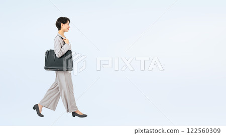 Full body photo of a walking middle-aged female business person 122560309