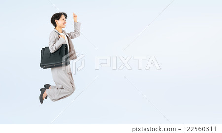 Full body photo of a middle-aged female business person jumping 122560311