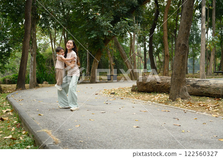Loving mother playing with her little son on a walking path in a beautiful park 122560327