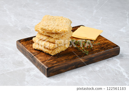 Delicious homemade cheese crackers paired with cheese and fresh herbs on a wooden board 122561183