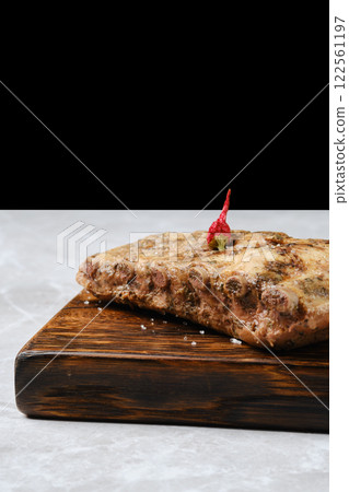 Close-up view of baked pork ribs on a rustic wooden board 122561197