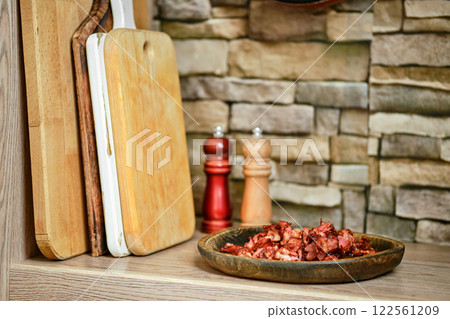 Chopped bacon served on a rustic plate in a cozy kitchen setting with wooden boards Chopped bacon served on a rustic plate in a cozy kitchen setting with wooden boards 122561209