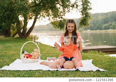 Mother And Baby Enjoying Picnic Outdoors Mother And Baby Enjoying Picnic Outdoors 122561366