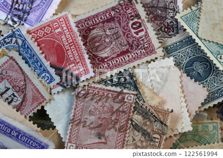 Closeup on a scattered collection of a variety of international used Vintage Postage Stamps Closeup on a scattered collection of a variety of international used Vintage Postage Stamps 122561994