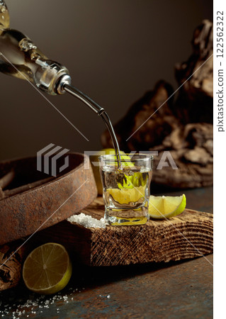 Tequila is poured from a bottle into a glass. 122562322