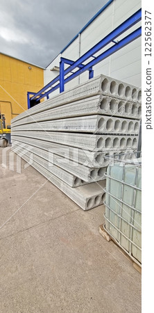 Stacked concrete slabs at an industrial site under a cloudy sky 122562377