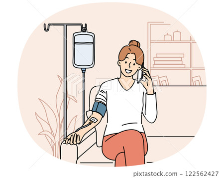 Happy woman receiving dropper with vitamins sitting on couch at home and talking to doctor on phone 122562427