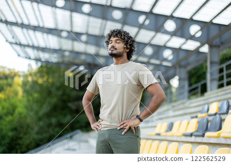 Athlete resting at the stadium, man breathing with eyes closed after active physical exercise and fitness. 122562529