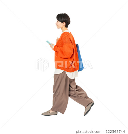 A stylish middle-aged woman walking with a smartphone. A transparent full-body photo PNG precisely cut by hand 122562744