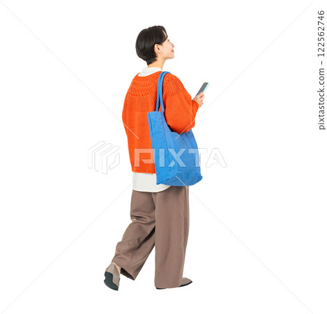 一位時尚的中年女性拿著智慧型手機行走。 122562746