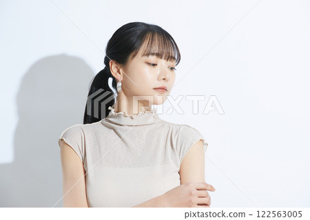 A refreshing beauty portrait of a young woman photographed against a light and shadow background 122563005