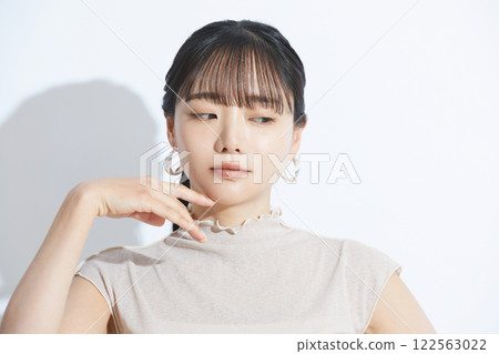 A refreshing beauty portrait of a young woman photographed against a light and shadow background 122563022