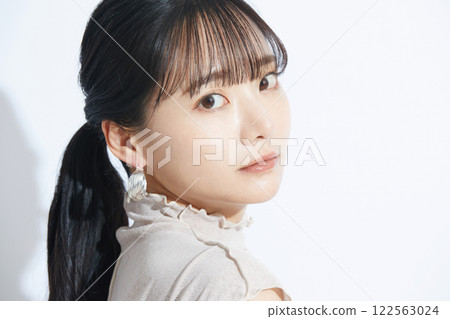 A refreshing beauty portrait of a young woman photographed against a light and shadow background A refreshing beauty portrait of a young woman photographed against a light and shadow background 122563024