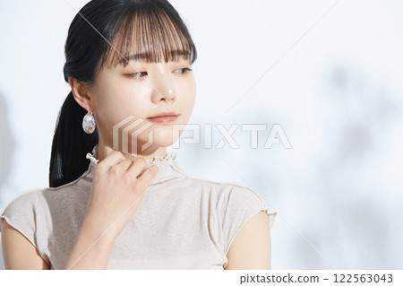 A refreshing beauty portrait of a young woman photographed against a light and shadow background 122563043