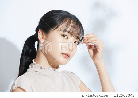 A refreshing beauty portrait of a young woman photographed against a light and shadow background A refreshing beauty portrait of a young woman photographed against a light and shadow background 122563045