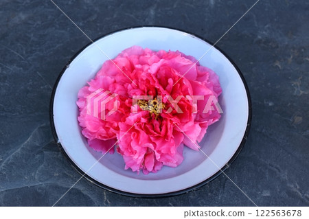 Big flower head of beautiful red tree peony, lat. Paeonia suffruticosa in a plate on the stone. Big flower head of beautiful red tree peony, lat. Paeonia suffruticosa in a plate on the stone. 122563678
