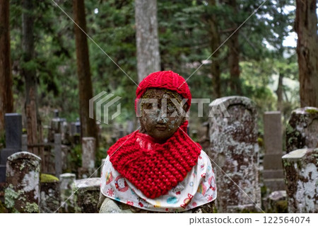Koyasan cemetery in Japan. Amazing Buddhist statue with knitted red clothing. Koyasan cemetery in Japan. Amazing Buddhist statue with knitted red clothing. 122564074