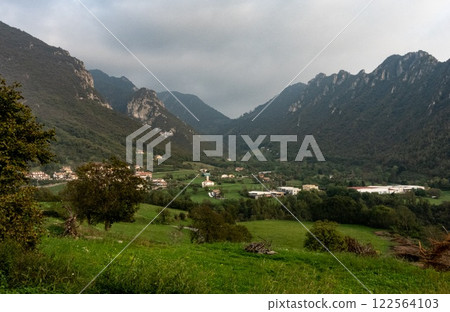 A scenic view of a picturesque valley surrounded by mountains A scenic view of a picturesque valley surrounded by mountains 122564103
