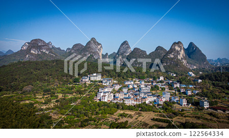 View of village surrounded by karst mountains near Guilin. Guanxi. China 122564334