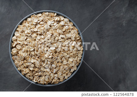 Oat Flakes in Bowl on Dark Gray Background, Copy Space 122564878