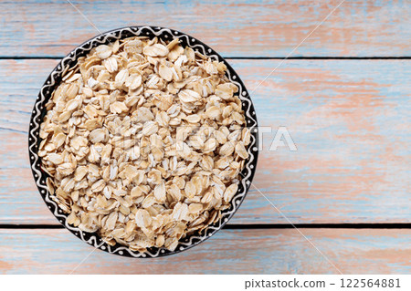 Uncooked Rolled Oats on Wooden Boards for Healthy Vegan Breakfast, Copy Space, Top View Uncooked Rolled Oats on Wooden Boards for Healthy Vegan Breakfast, Copy Space, Top View 122564881