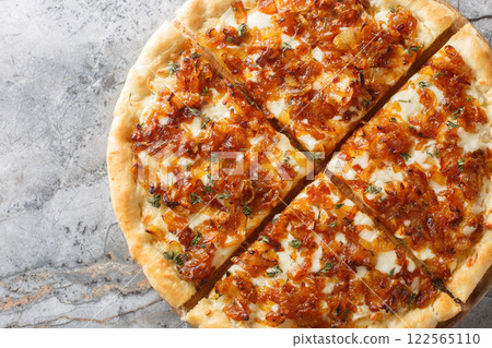 French onion pizza is basically a portable version of French onion soup, complete with both Gruyere and mozzarella cheese closeup on the wooden board. Horizontal top view French onion pizza is basically a portable version of French onion soup, complete with both Gruyere and mozzarella cheese closeup on the wooden board. Horizontal top view 122565110