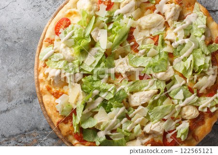 White Caesar pizza with chicken, lettuce, tomatoes, cheese and tender cream dressing closeup on the wooden board. Horizontal top view 122565121