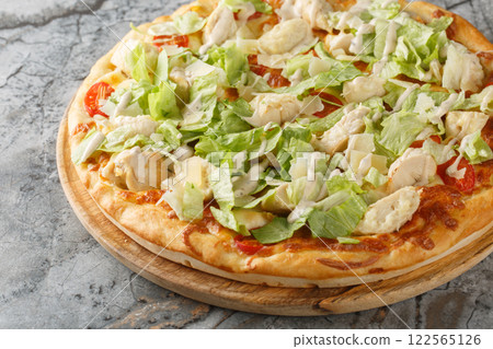 White Caesar pizza with chicken, lettuce, tomatoes, cheese and tender cream dressing closeup on the wooden board. Horizontal 122565126