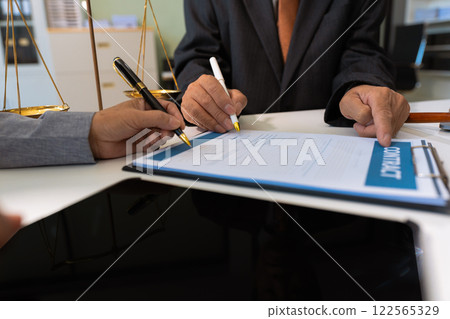 Business people and lawyers discussing contract papers sitting in the table at office in the morning. concepts of law, advice, legal services. Business people and lawyers discussing contract papers sitting in the table at office in the morning. concepts of law, advice, legal services. 122565329