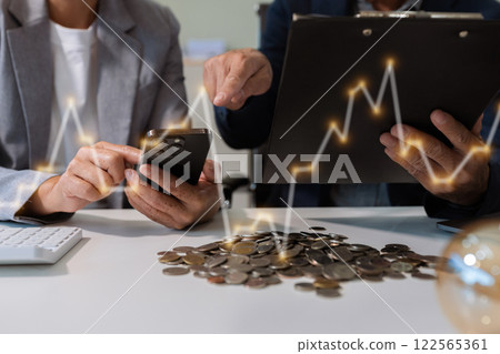businessman hand holding lightbulb with using laptop computer and money stack in office. idea saving energy and accounting finance concept in office. businessman hand holding lightbulb with using laptop computer and money stack in office. idea saving energy and accounting finance concept in office. 122565361