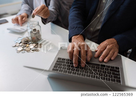 concept with saving money, accountant working on desk in home using calculator and laptop to calculate budget. concept with saving money, accountant working on desk in home using calculator and laptop to calculate budget. 122565369
