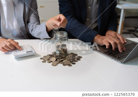 concept with saving money, accountant working on desk in home using calculator and laptop to calculate budget. concept with saving money, accountant working on desk in home using calculator and laptop to calculate budget. 122565370