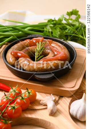 Close-up of grilled sausage with sauce. Close-up of grilled sausage with sauce. 122566142