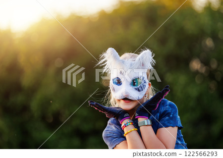 Cute young little kid girl wear cat furry mask enjoy have fun playing outdoors in forest street park. Children therian wild animal character trendy fan culture. Teenager social expression hobby Cute young little kid girl wear cat furry mask enjoy have fun playing outdoors in forest street park. Children therian wild animal character trendy fan culture. Teenager social expression hobby 122566293