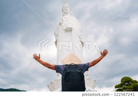 back of a male tourist traveler at Lady Buddha statue at Linh Ung Pagoda in Da Nang in Vietnam. Concept of travel and tourism in Asia 122567241