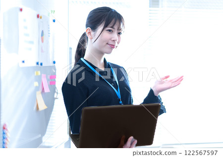 Young businesswoman giving a presentation using a whiteboard 122567597