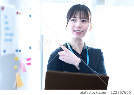Young businesswoman giving a presentation using a whiteboard Young businesswoman giving a presentation using a whiteboard 122567600