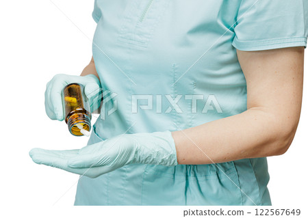 Female physician pours capsules out of the glass bottle. 122567649