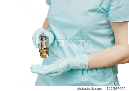 Female physician pours capsules out of the glass bottle. Female physician pours capsules out of the glass bottle. 122567651